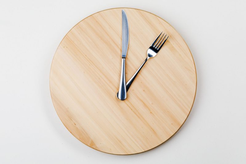 Bandeja redonda de madera con Cubertería en forma de manos de reloj