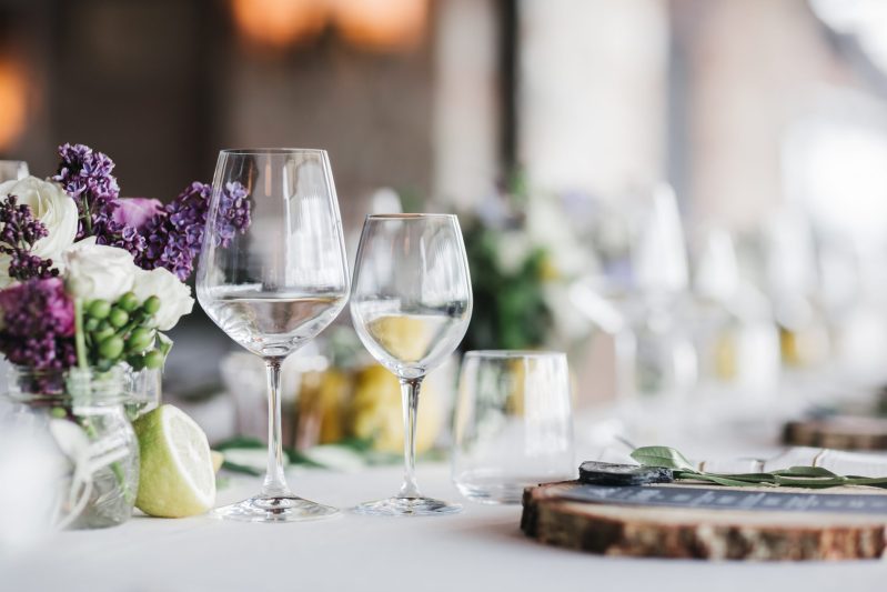 Mesa decorada con flores y copas vacías